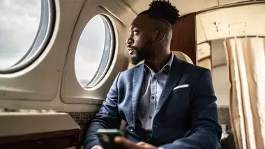 Businessman on a private plane looking out a window.