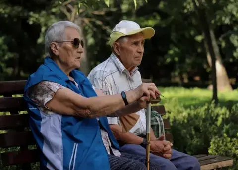 Older couple sitting on a park bench.